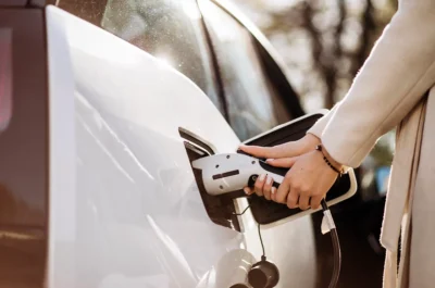 Elektrikli otomobilini şarj eden araç sahibi kadın